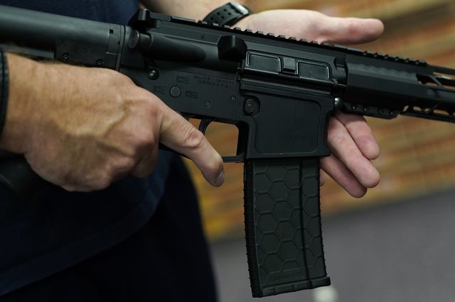 A customer handles an AR-15 at Jimmy's Sport Shop in Mineola, New York in 2020. Legislators are asking credit card companies to put gun store purchases in their own tracking category, to make it easier to flag suspicious activity and notify law enforcement.